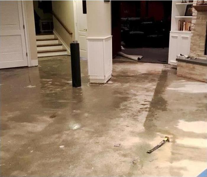 Residential basement with significant flood damage and water on floor and walls
