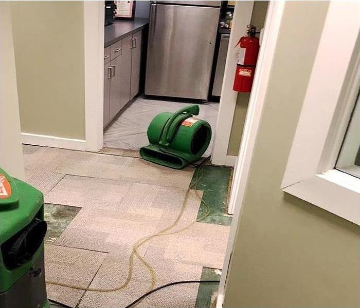 Commercial water damage to business kitchen, air movers and fans to dry floor and walls